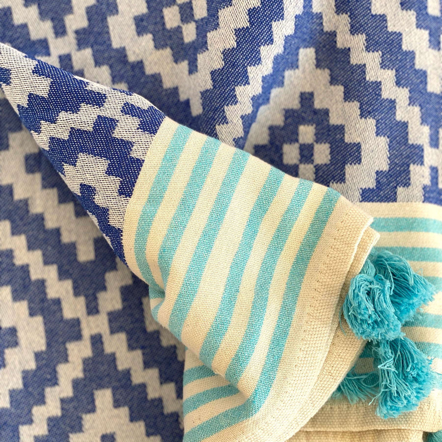 Merida Turkish Towel in blue with hand-knotted tassels, showcasing its unique design and eco-friendly materials.