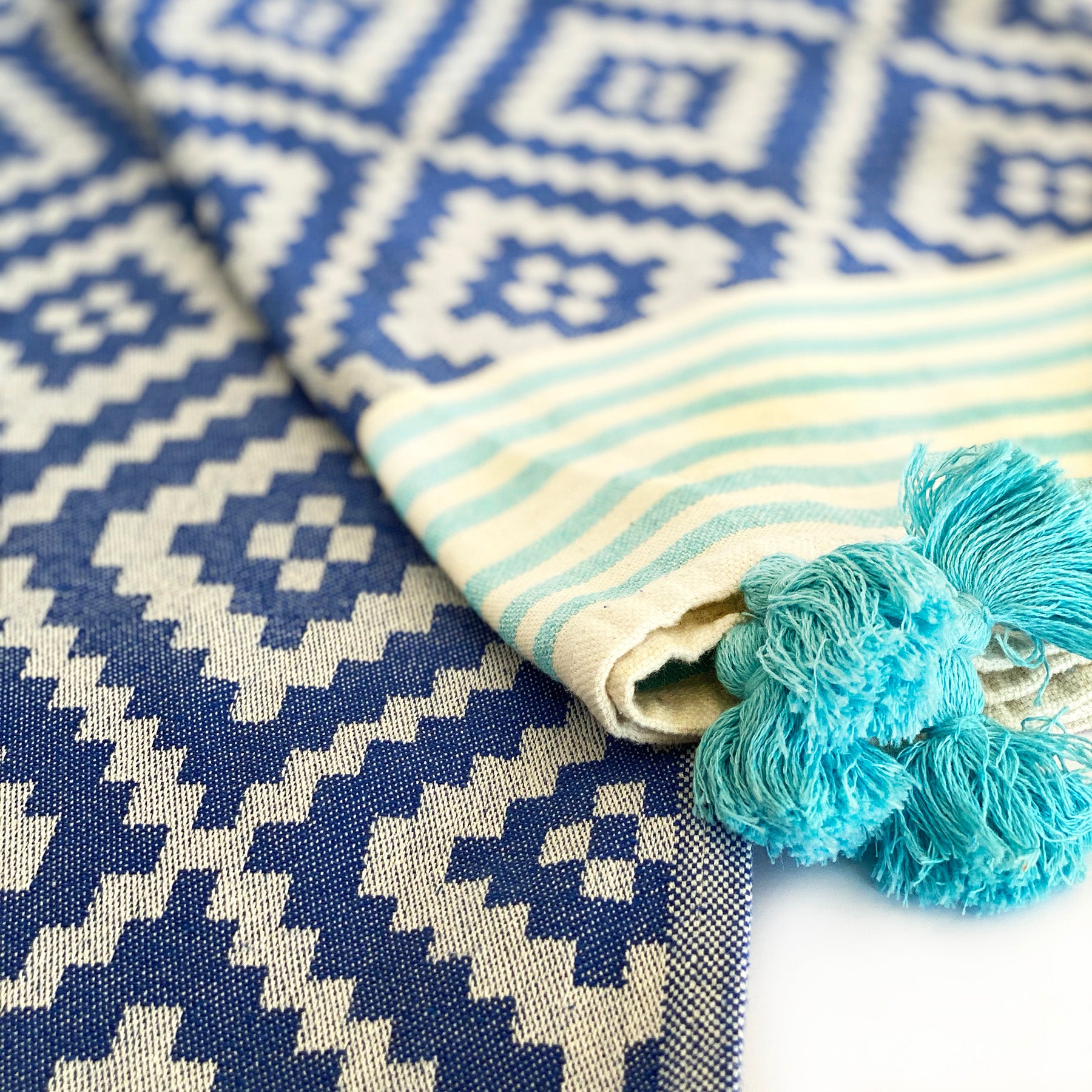 Merida Turkish Towel in blue with hand-knotted tassels, showcasing its unique design and eco-friendly materials.