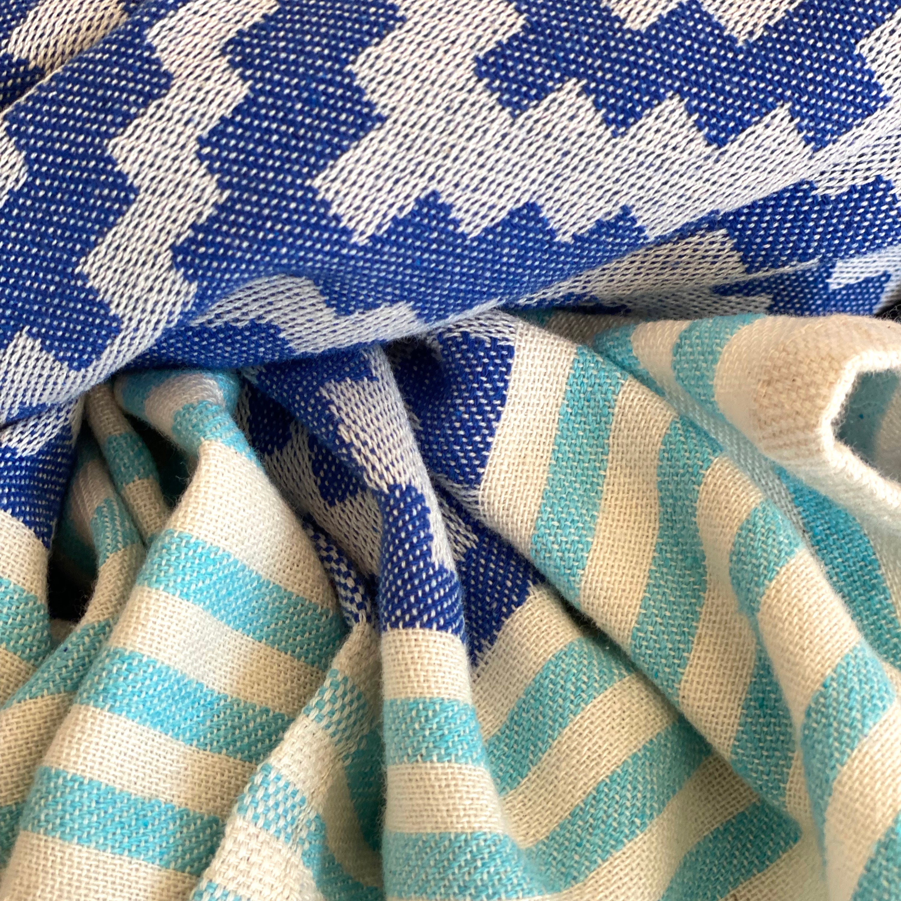 Merida Turkish Towel in blue with hand-knotted tassels, showcasing its unique design and eco-friendly materials.