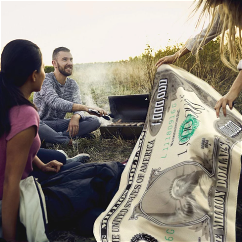 A plush Million-dollar Novelty Blanket made of high-quality flannel, featuring realistic prints and a cozy design, perfect for lounging or travel.