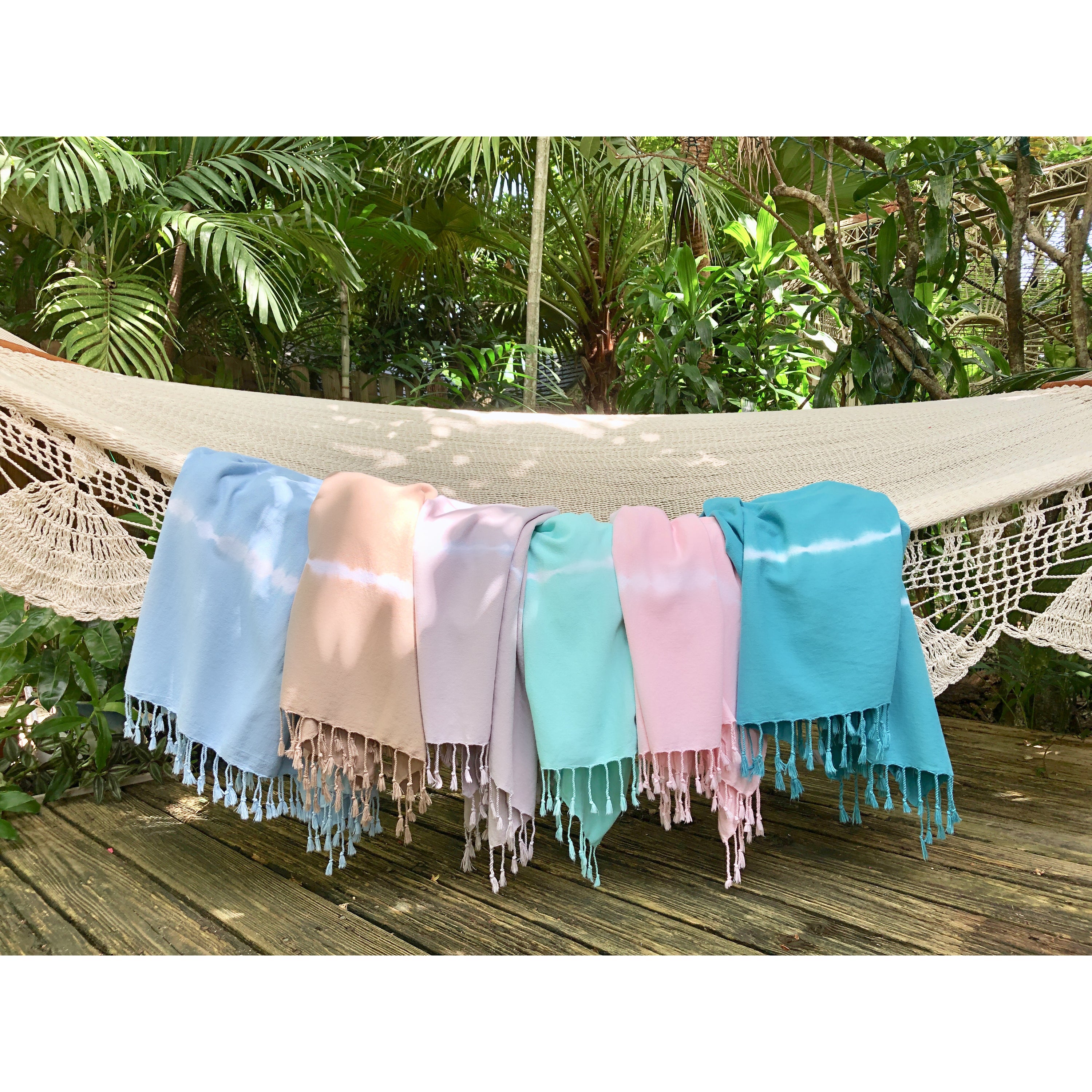 Mint Tie Dye Turkish Beach Towel displayed on a sandy beach, showcasing its vibrant colors and texture.