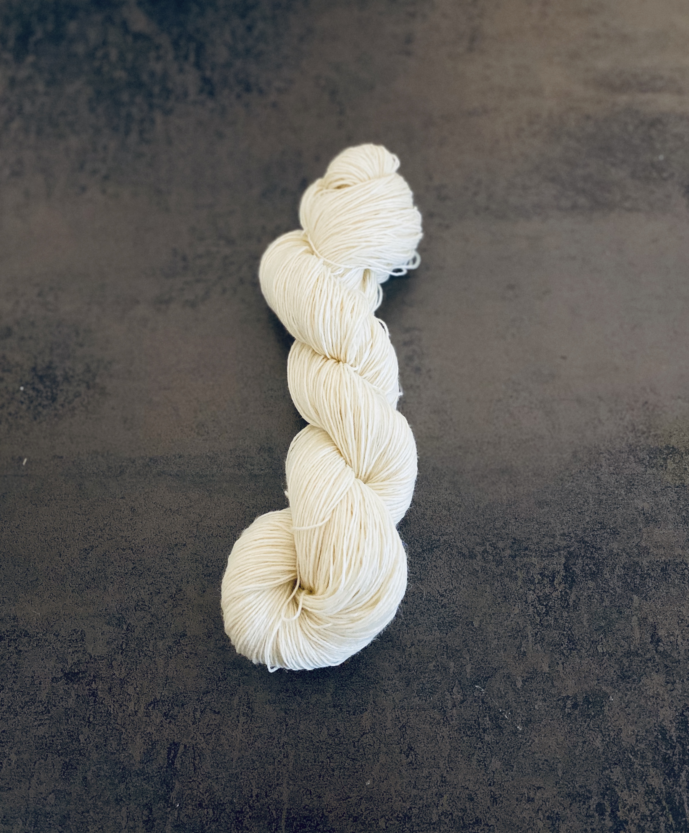 Beige yarn skein on table.