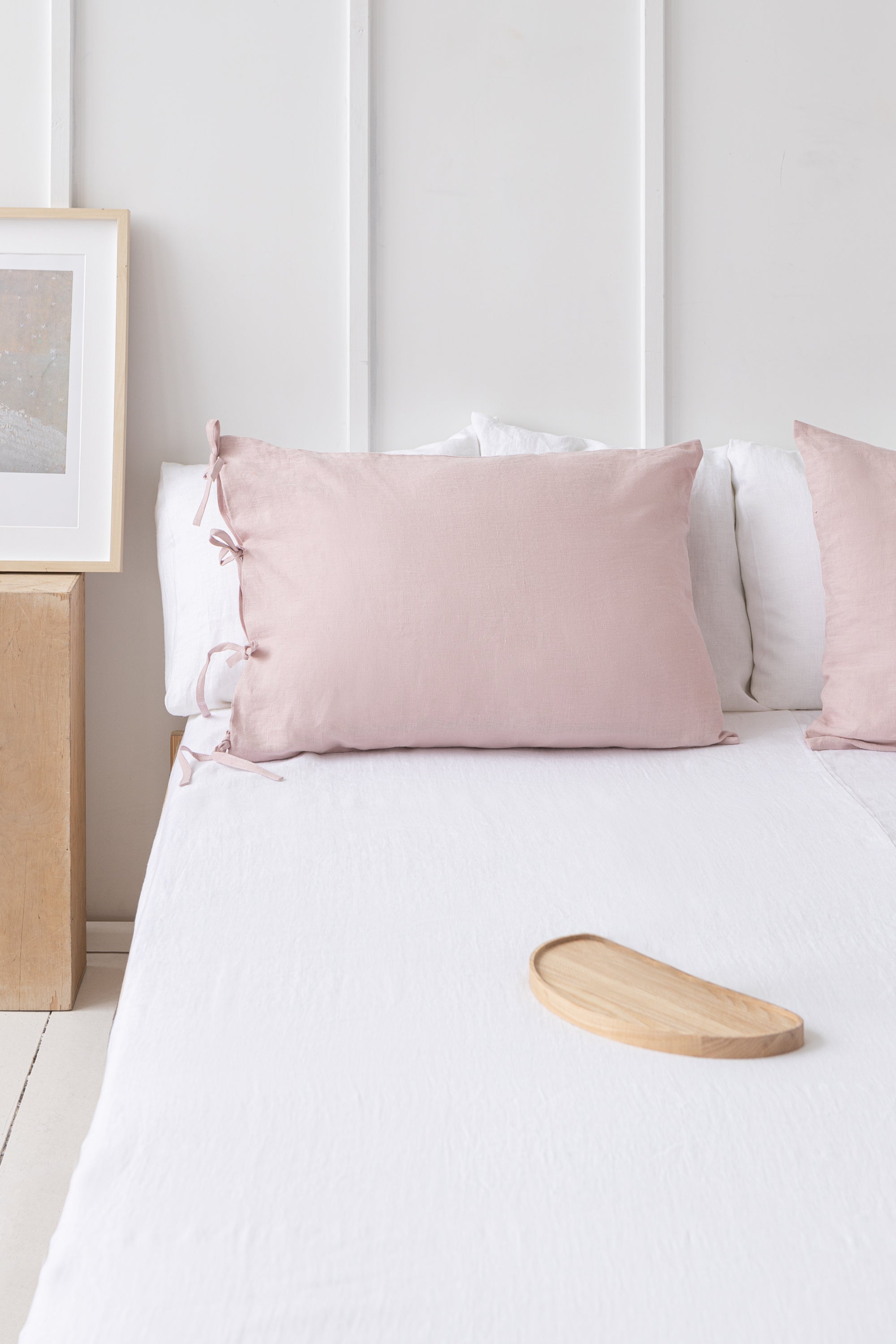 Elegant pale pink linen pillowcase with ties, showcasing soft texture and stylish design, perfect for enhancing bedroom decor.