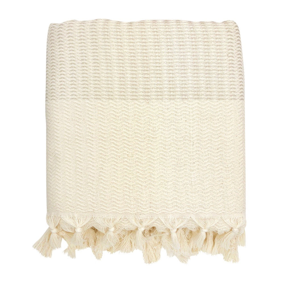 A cozy Plush Wavy Turkish Throw featuring intricate wave patterns and hand-knotted fringe, perfect for home decor.