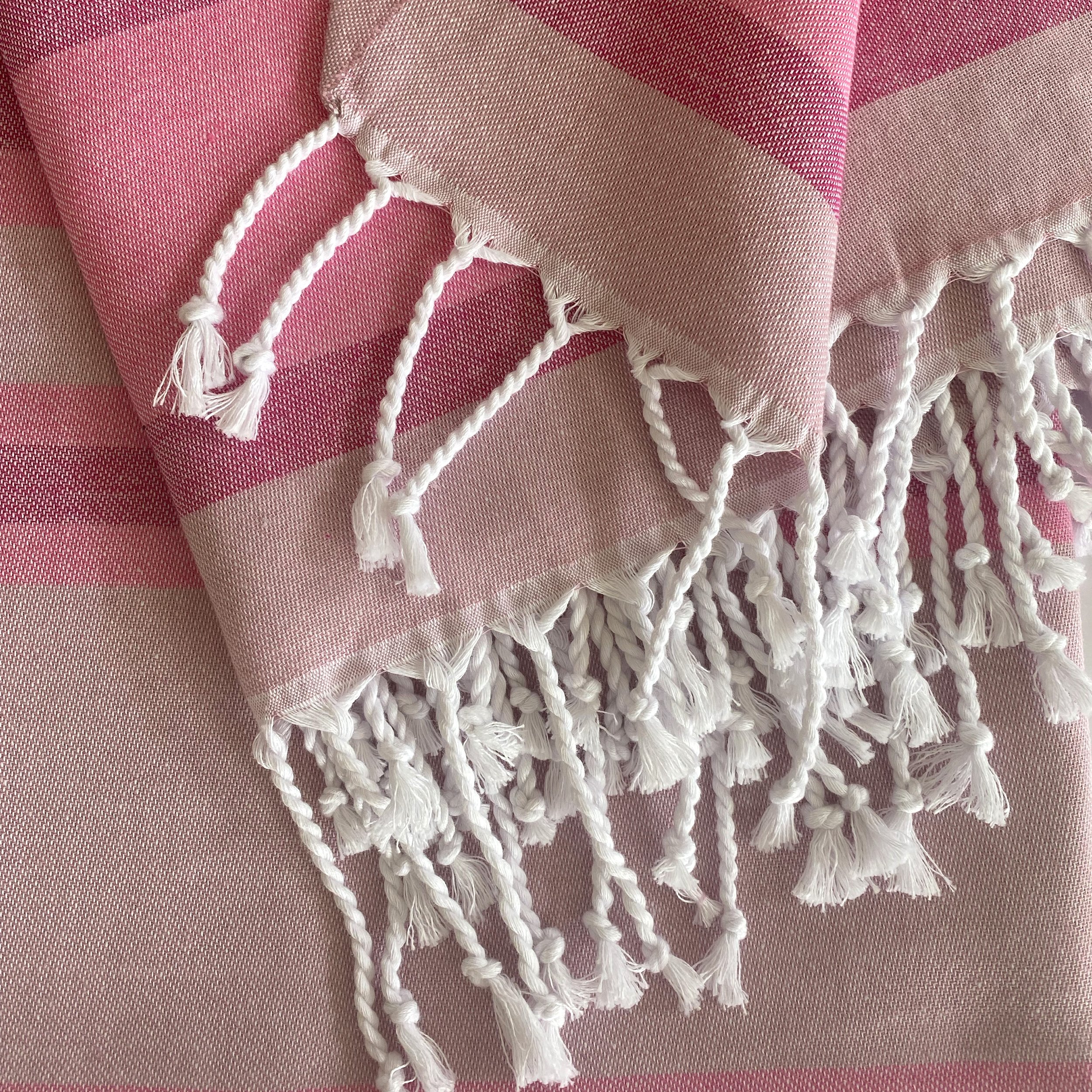 Samara Sustainable Turkish Towel in Pink with hand-tied tassels, showcasing its soft texture and eco-friendly design.
