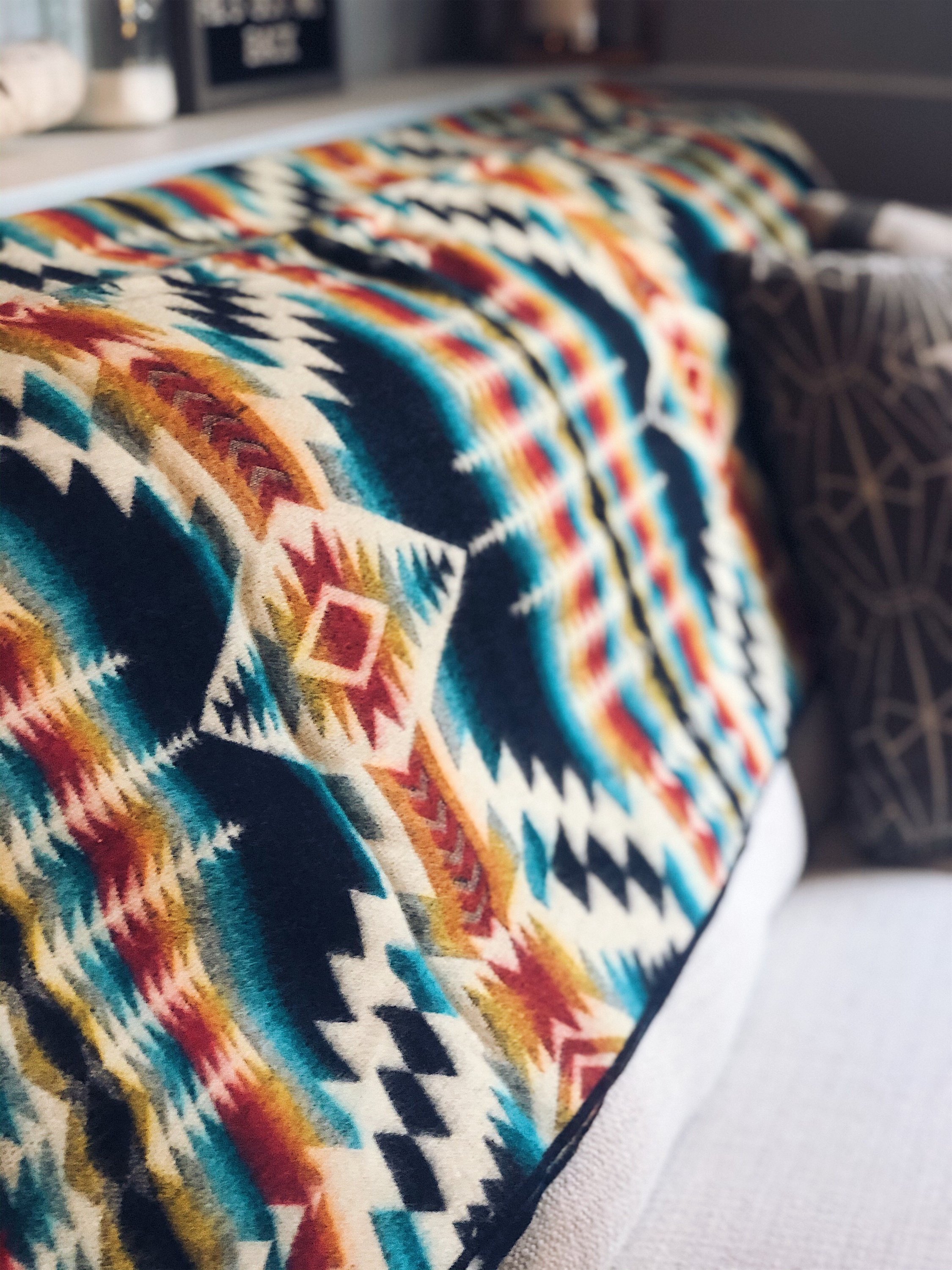 Secoya Blanket - Northern Lights featuring vibrant colors and intricate patterns, handcrafted by Ecuadorian artisans, perfect for cozying up or outdoor use.