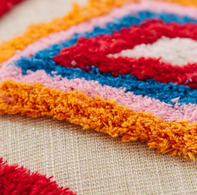 Handmade tassel tufted knitted cushion cover in geometric art design, featuring soft cotton and linen material with a zipper closure.