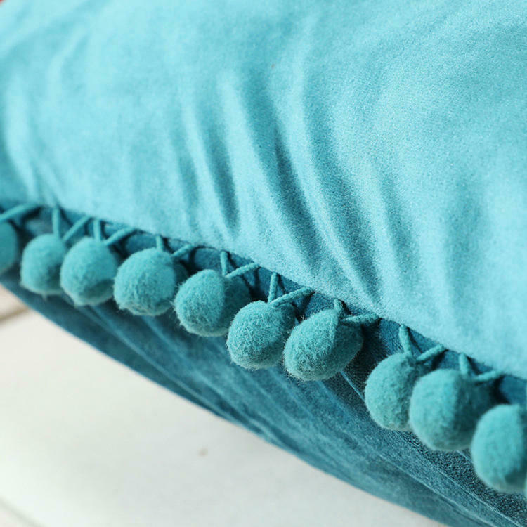 Tassel velvet cushion covers with pom poms in a stylish arrangement, showcasing their soft texture and vibrant color.