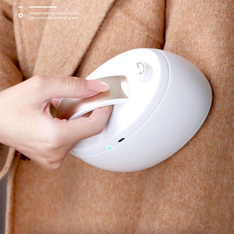 Rechargeable fabric shaver in white and gold, designed for removing lint and fuzz from various fabrics.