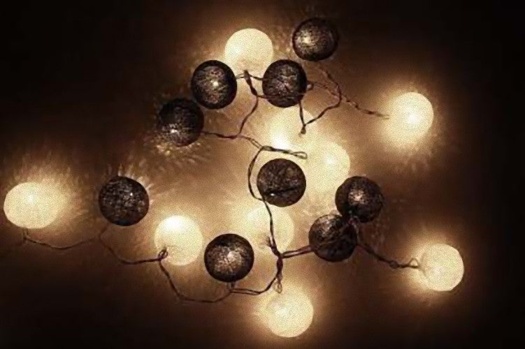 A string of 20 black and white cotton ball fairy lights, each 5cm in diameter, battery powered for versatile decoration.
