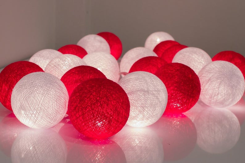 A set of 20 LED red and white cotton ball string lights, showcasing vibrant colors and a cozy glow, perfect for decoration.