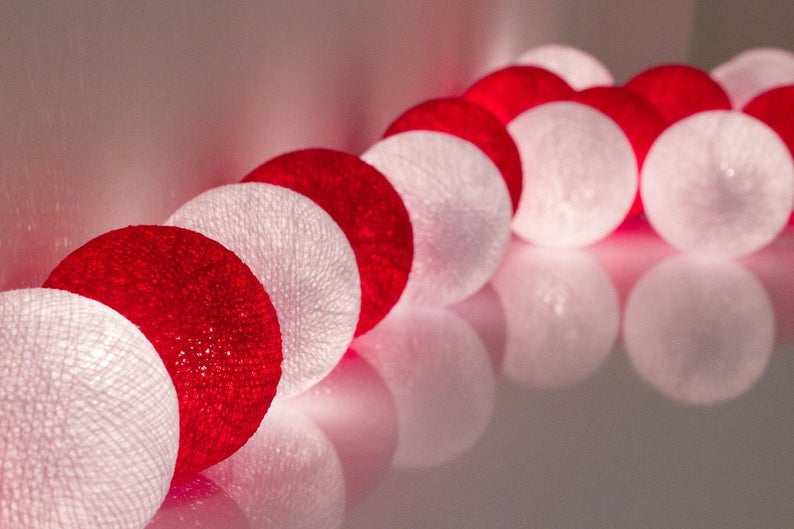 A set of 20 LED red and white cotton ball string lights, showcasing vibrant colors and a cozy glow, perfect for decoration.