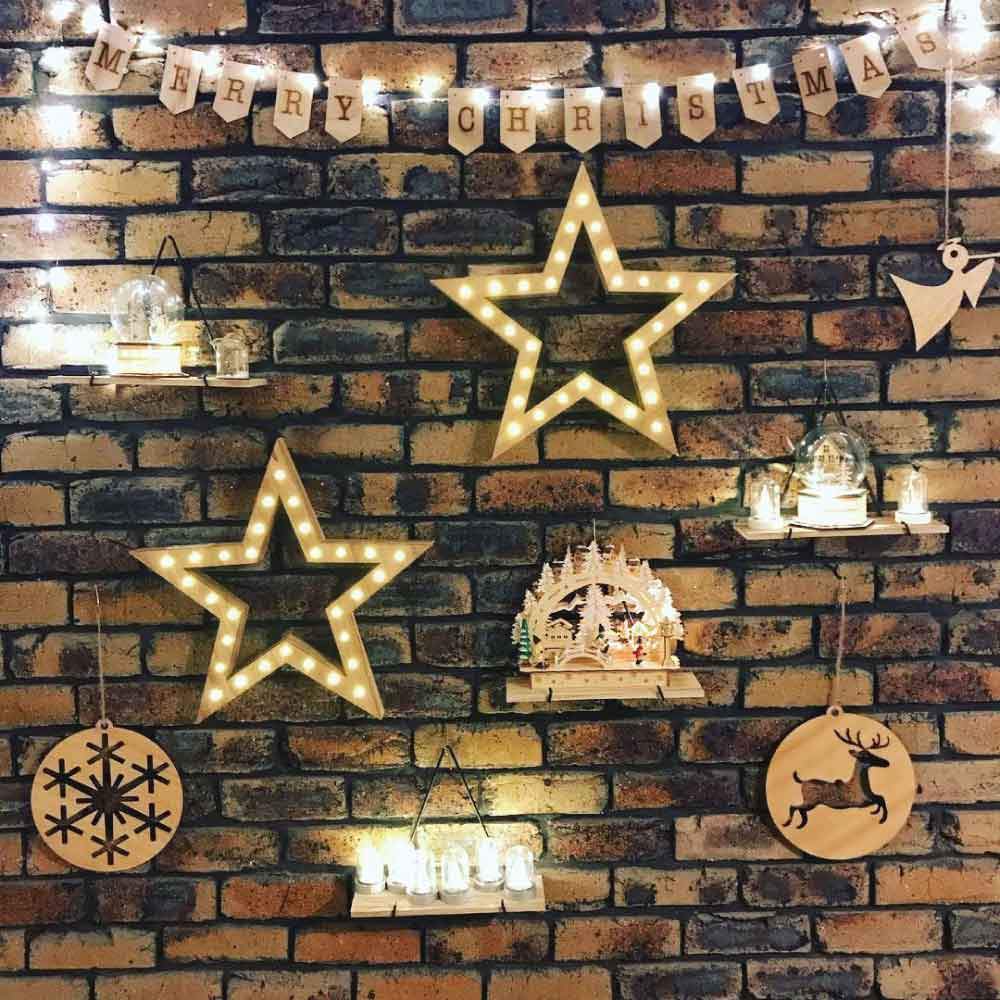 A pack of 10 Bric Crab Brick Hooks designed for hanging items on external bricks, showcasing their stainless steel construction and spring design.