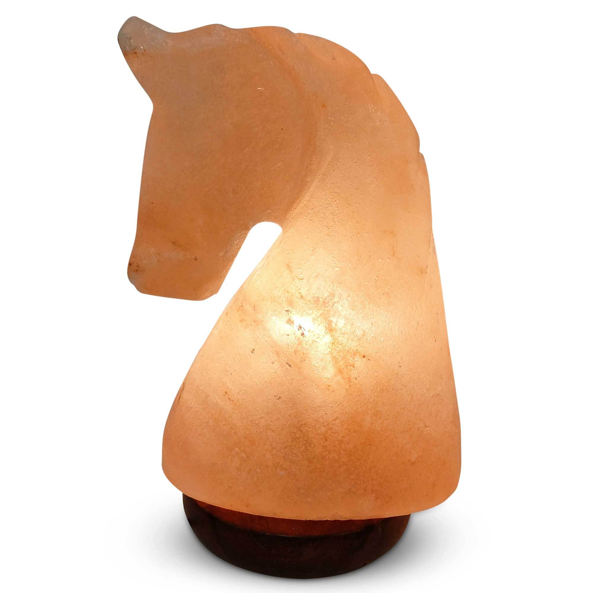 A beautifully carved knight horse-shaped Himalayan pink salt lamp, glowing warmly on a wooden base, showcasing its unique natural textures.