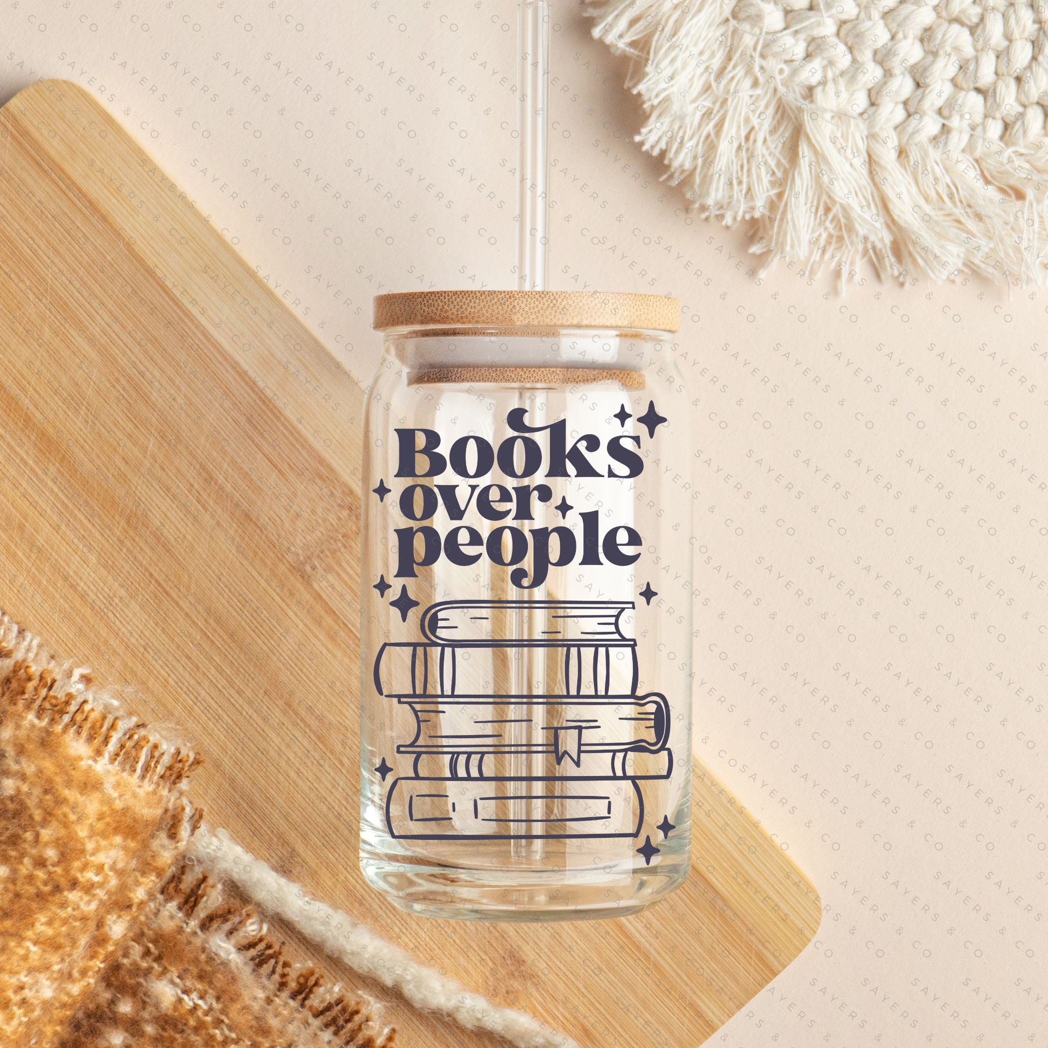16oz Books Over People Glass Cup featuring a bamboo lid and straw, perfect for iced coffee and cocktails.