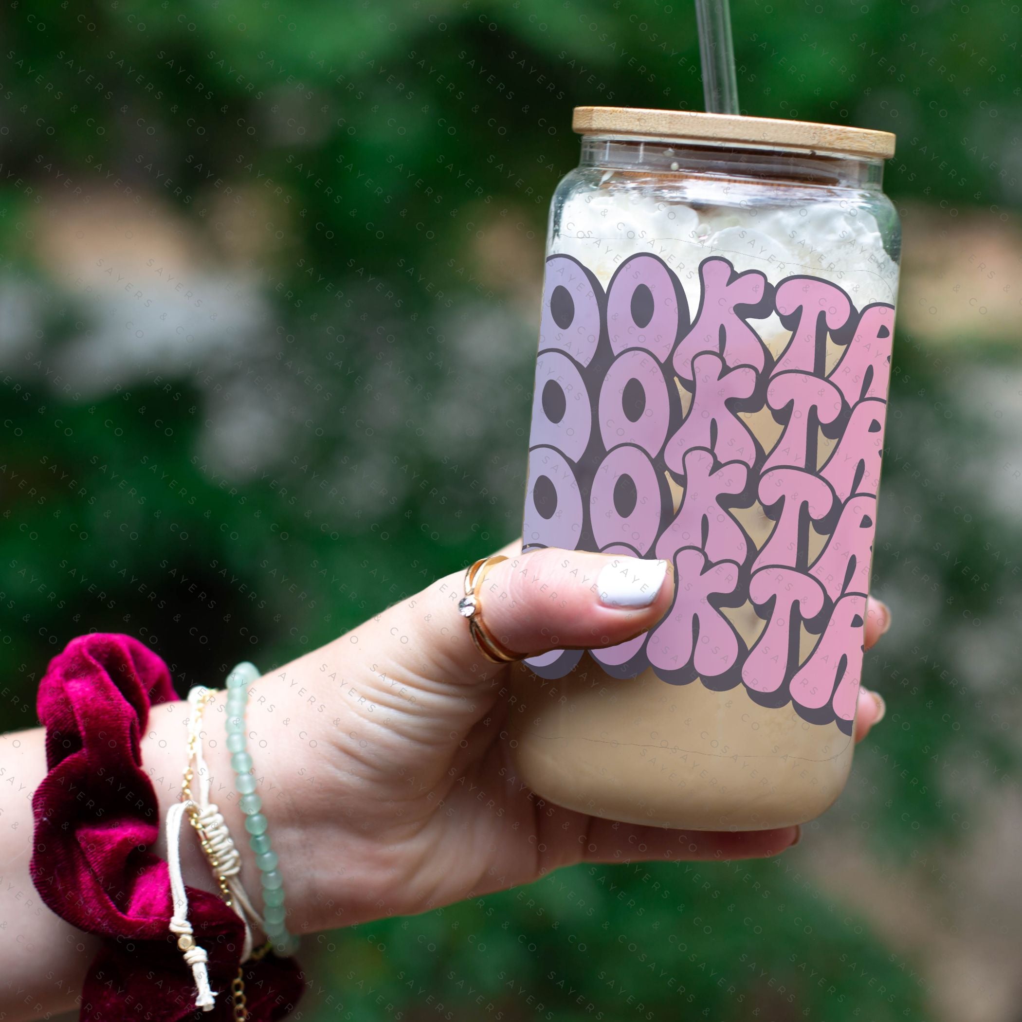 16oz Booktrovert Glass Cup featuring a bamboo lid and clear straw, perfect for iced coffee and other beverages.