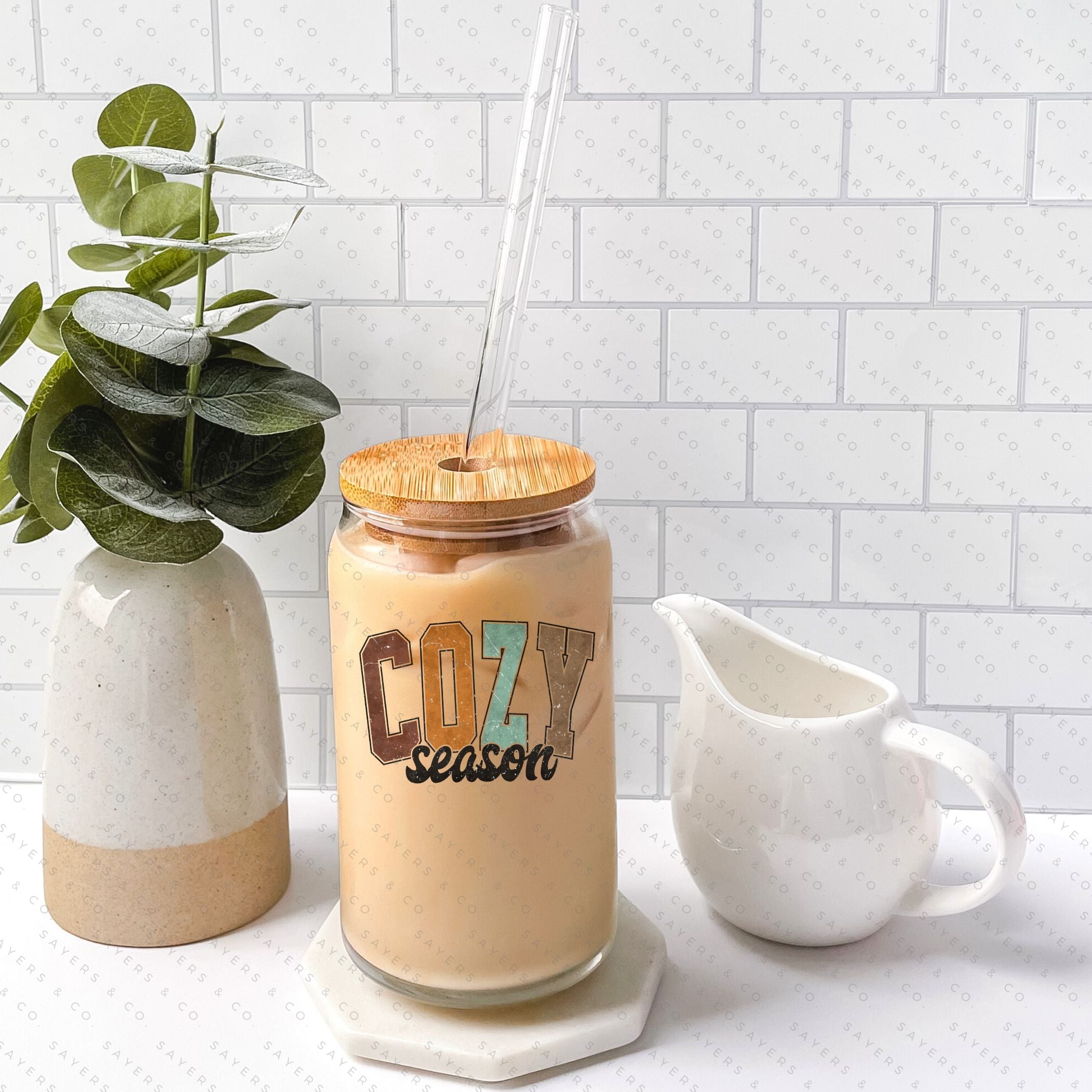 16oz Cozy Season Glass Cup with Bamboo Lid and Straw, featuring a clear or frosted design, perfect for seasonal beverages.