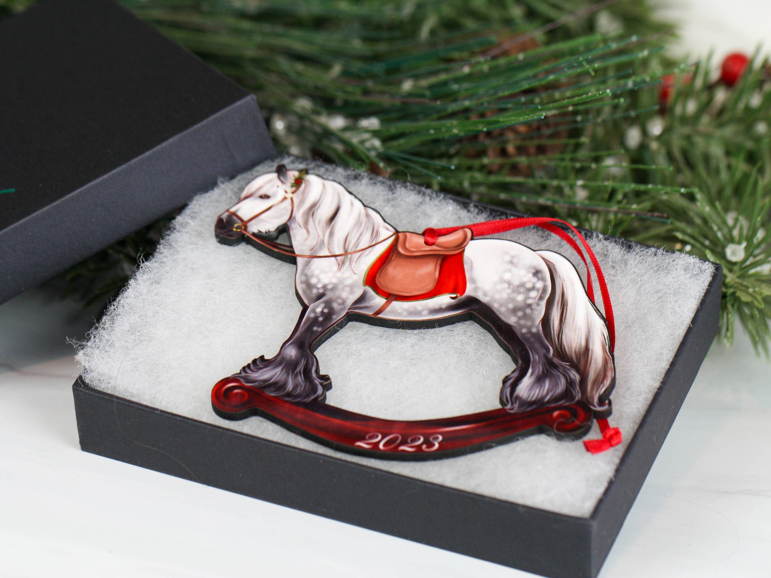 2023 Gray Gypsy Rocking Horse Christmas Ornament, handmade from composite wood with a glossy finish, featuring red and black ribbons.