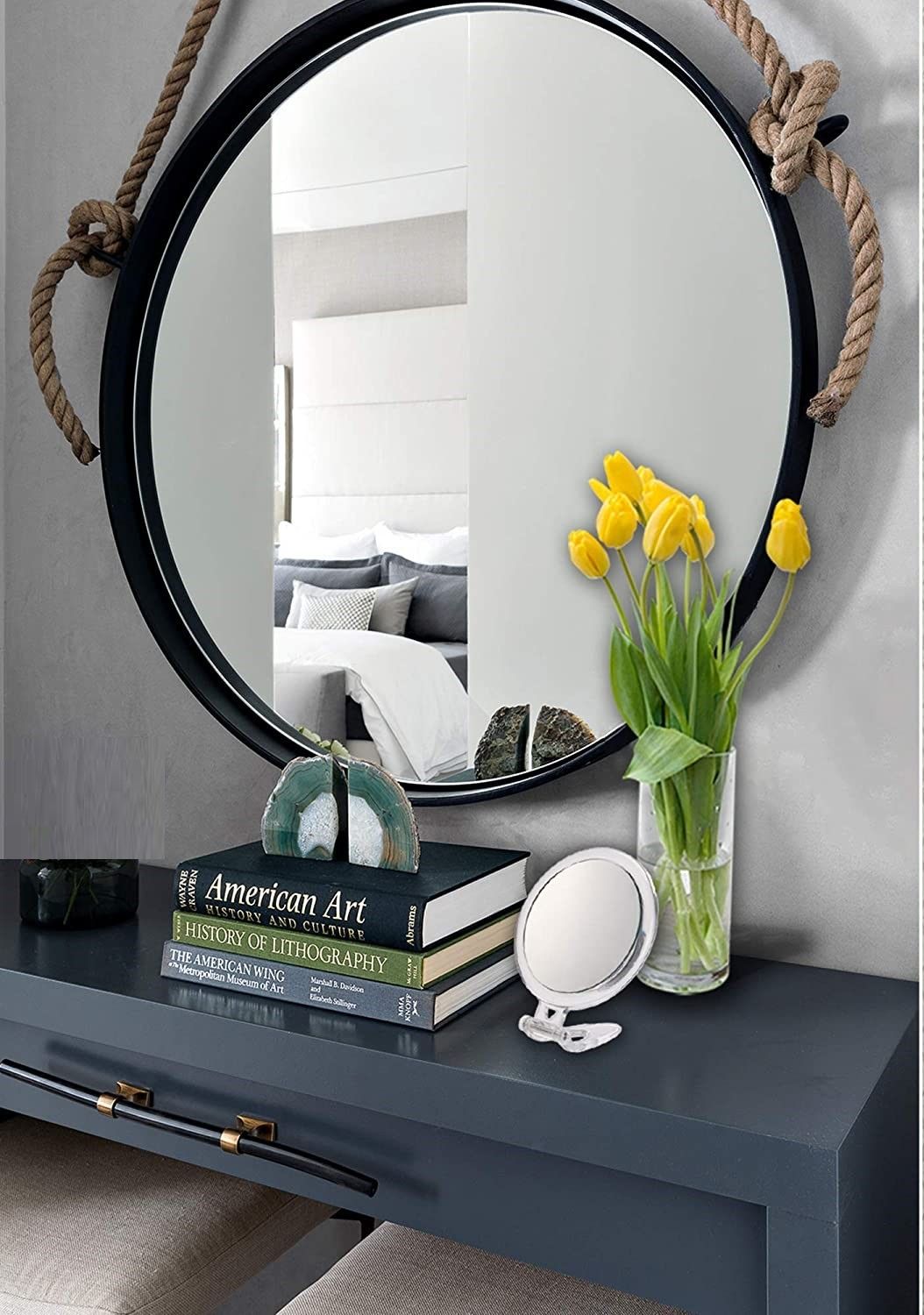 A 20X magnifying hand mirror with a black frame, showcasing two sides: one with 20X magnification and the other with a true image reflection, ideal for makeup application.