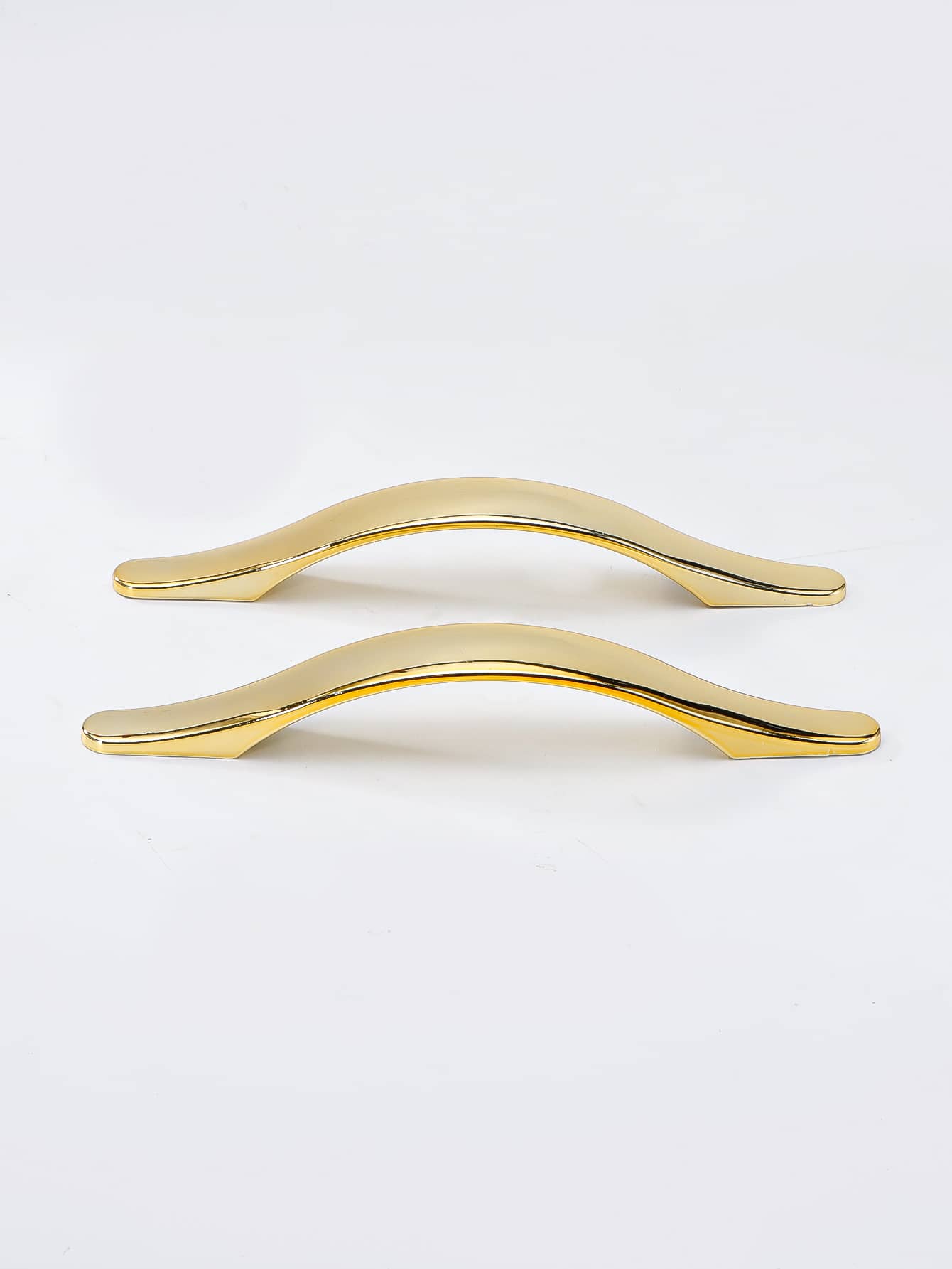 Two golden plastic handles designed for furniture, showcasing their elegant shape and finish.