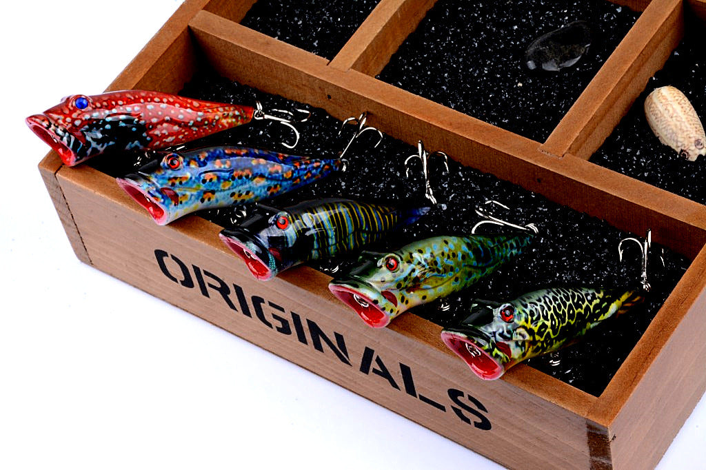 Five colorful 8cm popper fishing lures with sharp hooks, designed for effective surface fishing in both saltwater and freshwater.