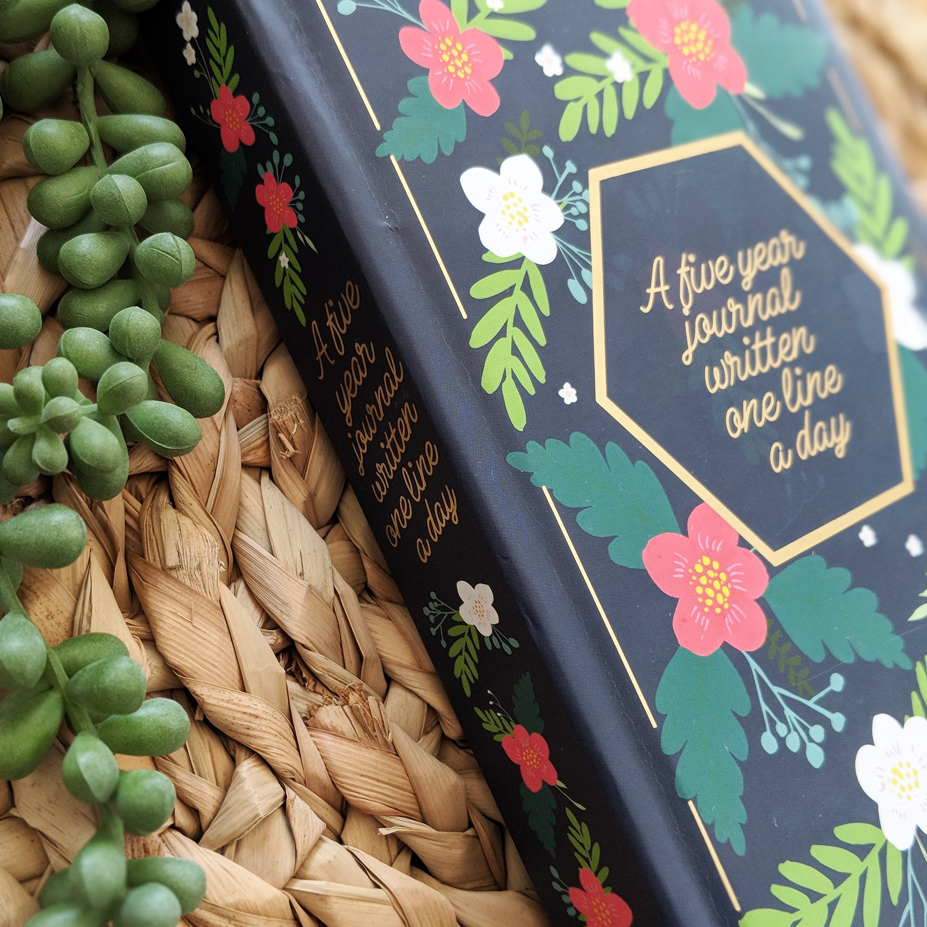 A beautiful navy floral five-year journal with gold accents, featuring a bookmark ribbon and gold foil edges, perfect for daily reflections.
