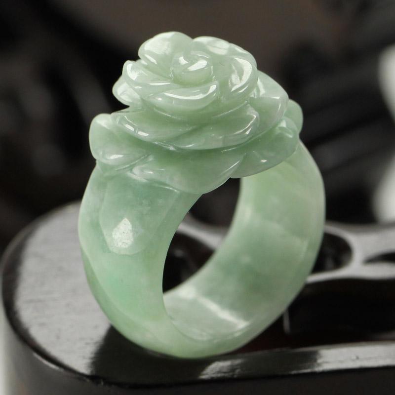 A beautiful Burma Jade ring featuring small green flowers, showcasing intricate details and vibrant colors.