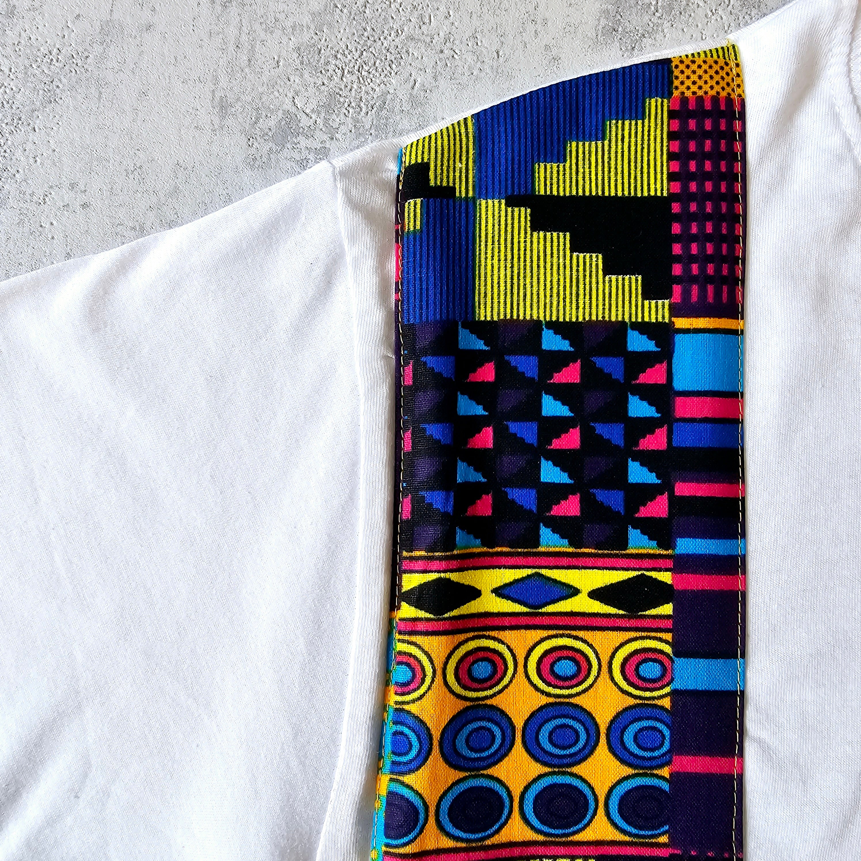 Africa Print Detailed T-Shirt featuring Ankara pocket design, made from soft cotton jersey, displayed on a neutral background.