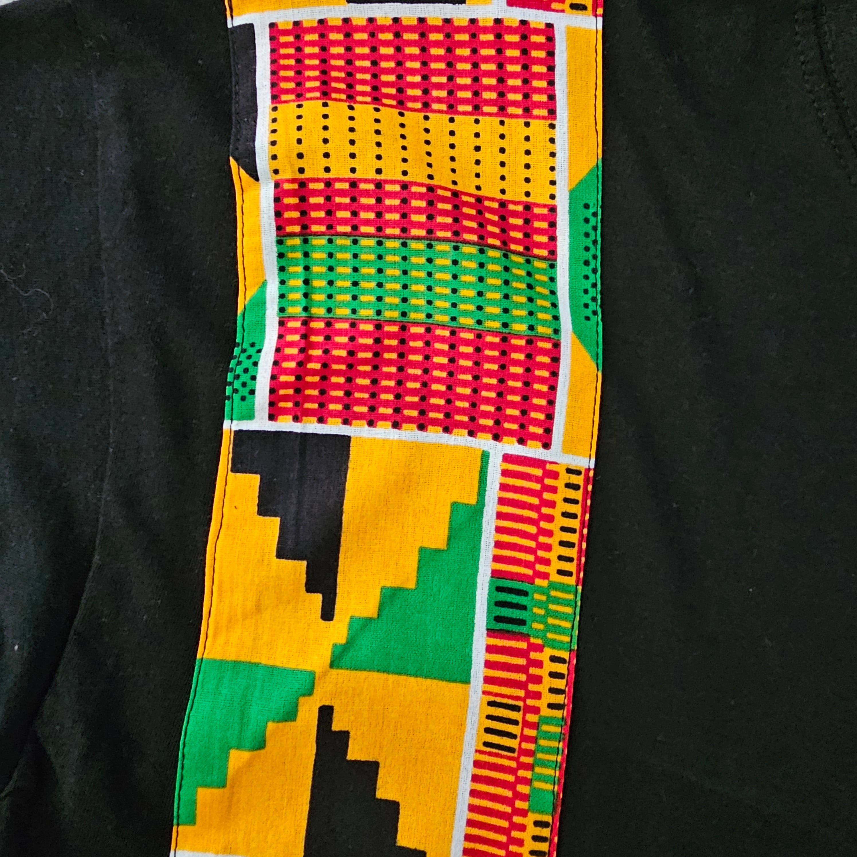 A stylish black unisex t-shirt featuring unique Bogolan print details on the pocket and sleeves, made from soft 100% cotton.