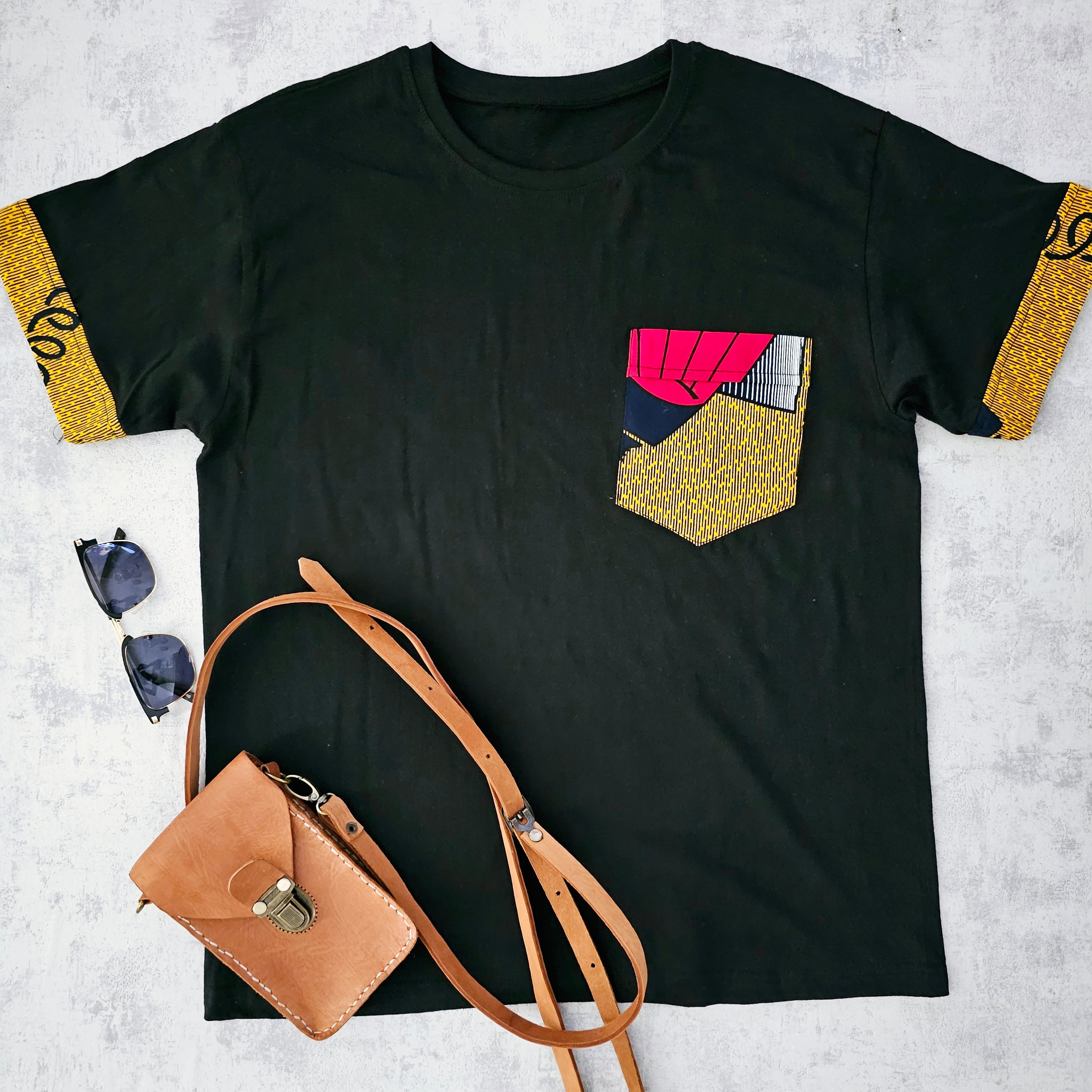 Black unisex t-shirt featuring unique Bogolan print detail and pocket, made from 100% soft cotton jersey.