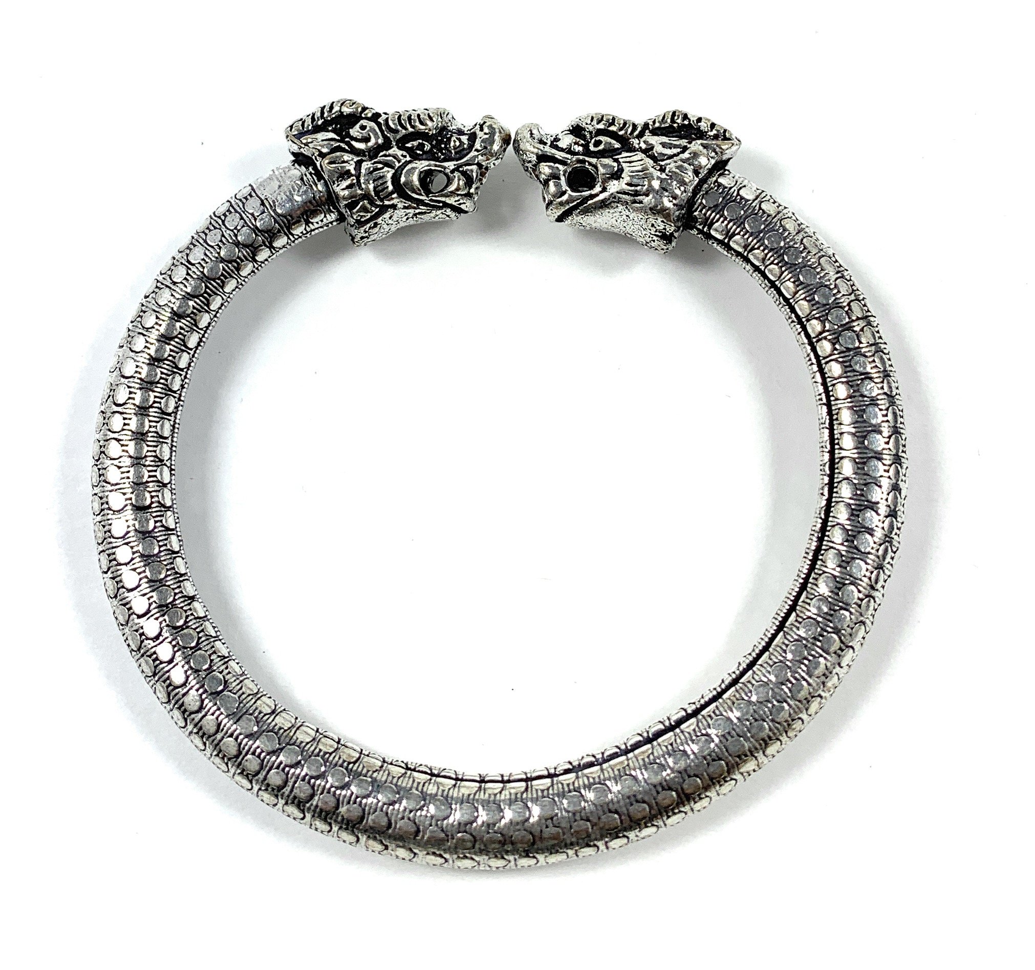 Antique Norse bracelet featuring lion heads and dotted design, showcasing intricate craftsmanship and vintage style.