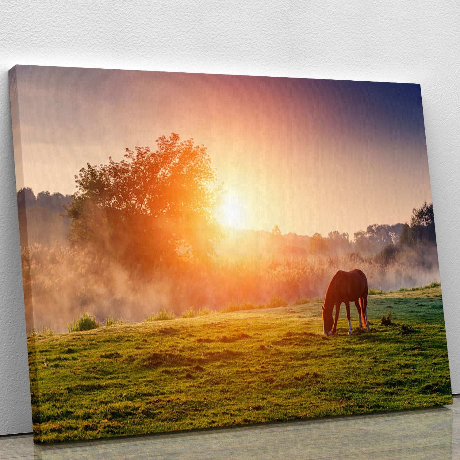 A beautiful canvas print of Arabian horses grazing in a sunlit pasture at sundown, showcasing warm orange hues.