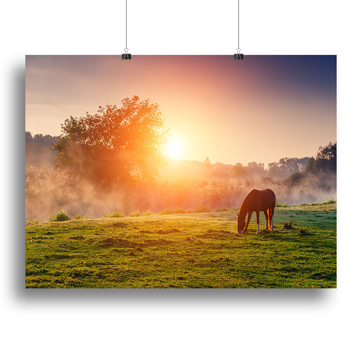 A beautiful canvas print of Arabian horses grazing in a sunlit pasture at sundown, showcasing warm orange hues.