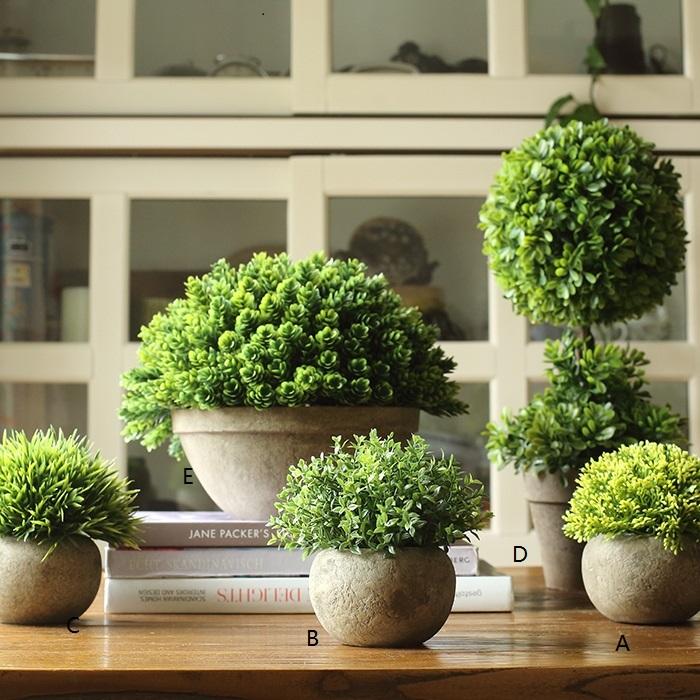 A collection of handmade artificial faux boxwood topiaries in various designs and sizes, showcasing their realistic green foliage.