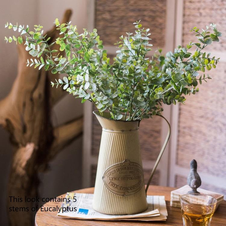 A tall 26-inch artificial eucalyptus stem in vibrant green, showcasing realistic leaves and a slender design, perfect for home decor.