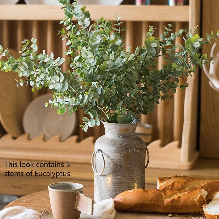 A tall 26-inch artificial eucalyptus stem in vibrant green, showcasing realistic leaves and a slender design, perfect for home decor.