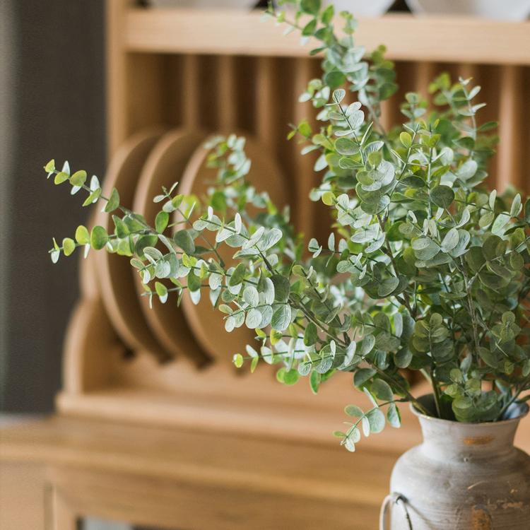 A tall 26-inch artificial eucalyptus stem in vibrant green, showcasing realistic leaves and a slender design, perfect for home decor.