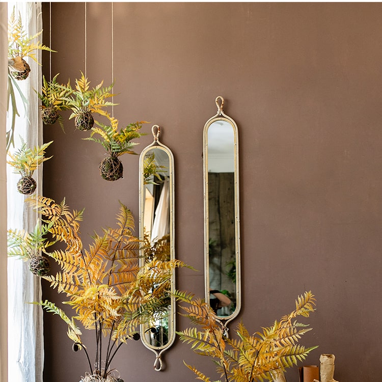 A vibrant artificial fern ball faux plant in fall colors, showcasing green, yellow, and brown hues, perfect for home decor.