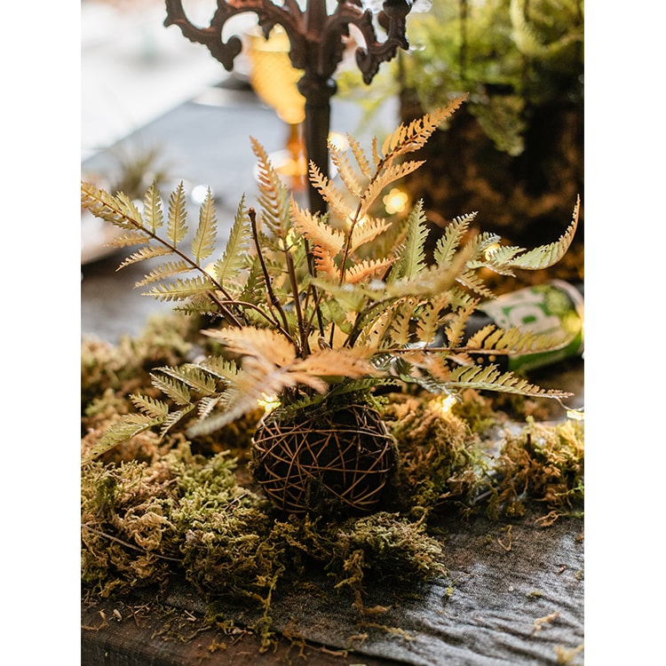 A vibrant artificial fern ball faux plant in fall colors, showcasing green, yellow, and brown hues, perfect for home decor.