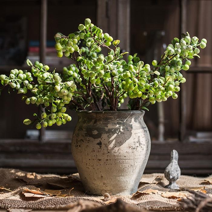A 17-inch tall artificial berry stem in vibrant green, featuring realistic latex-coated berries and leaves, perfect for home decor.