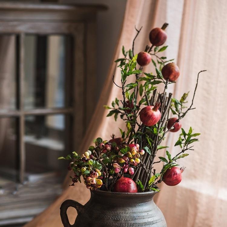 A tall artificial red pomegranate fruit stem with five realistic pomegranate fruits and green leaves, standing 36 inches tall.
