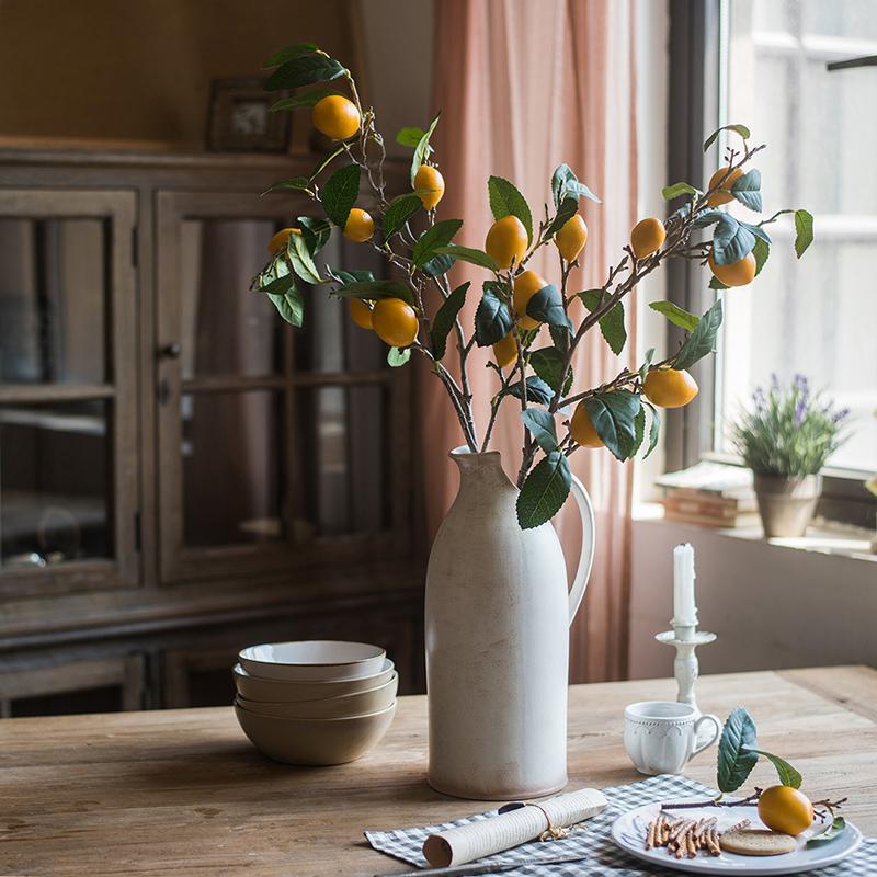 A 39-inch tall artificial lemon stem featuring eight vibrant silk lemons in green and yellow colors, perfect for home decor.
