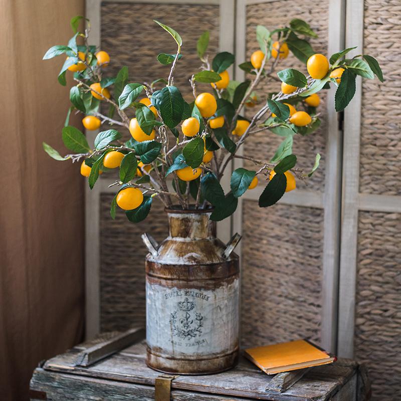 A 39-inch tall artificial lemon stem featuring eight vibrant silk lemons in green and yellow colors, perfect for home decor.