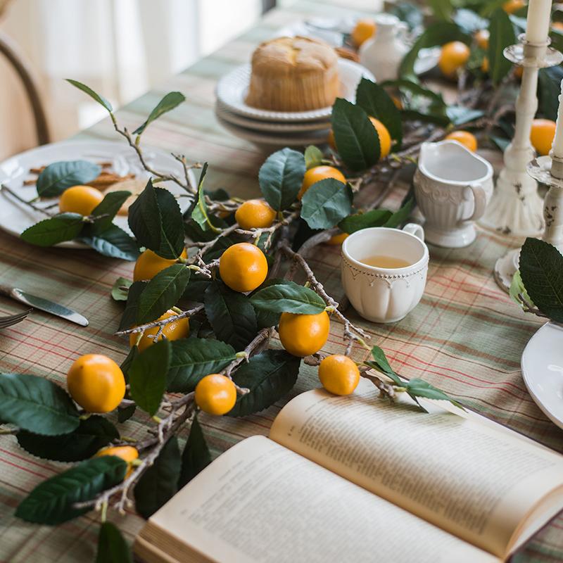 A 39-inch tall artificial lemon stem featuring eight vibrant silk lemons in green and yellow colors, perfect for home decor.