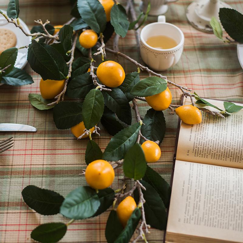 A 39-inch tall artificial lemon stem featuring eight vibrant silk lemons in green and yellow colors, perfect for home decor.