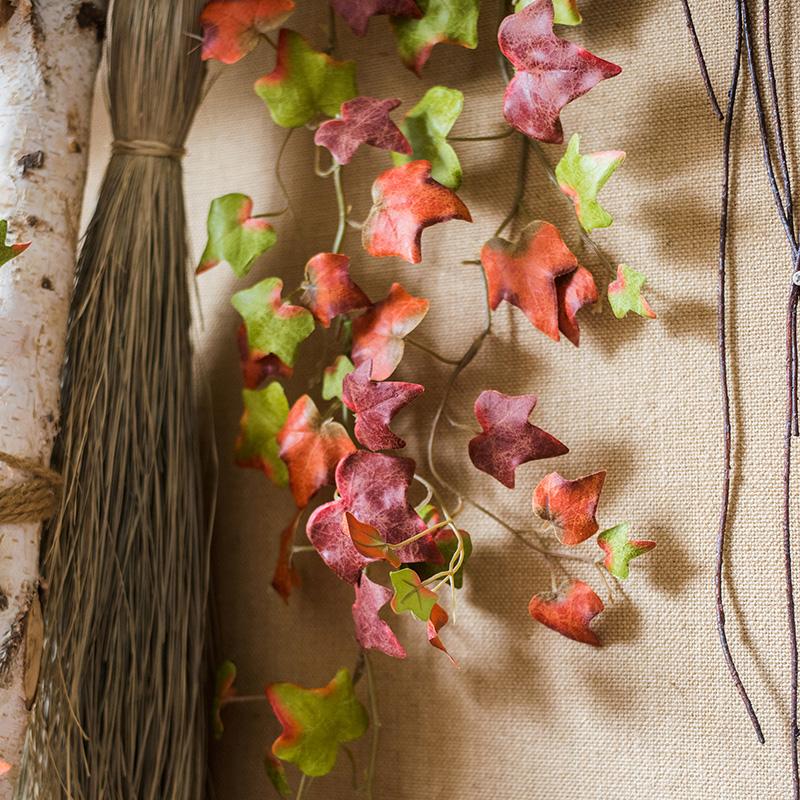A 43-inch long artificial ivy vine featuring vibrant autumn colors including orange, brown, green, and red, perfect for seasonal decor.