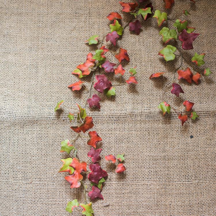 A 43-inch long artificial ivy vine featuring vibrant autumn colors including orange, brown, green, and red, perfect for seasonal decor.