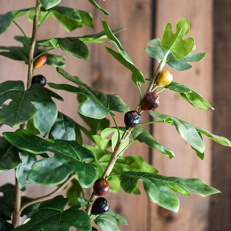 A realistic artificial silk fig tree in a decorative pot, showcasing vibrant green leaves and a lifelike appearance.