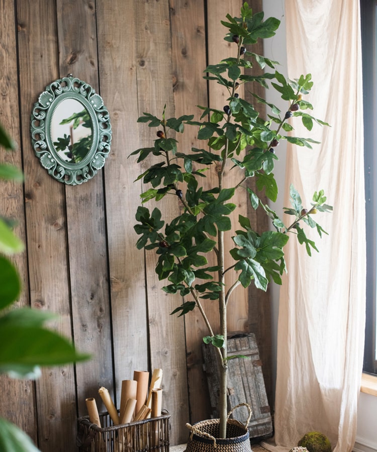 A realistic artificial silk fig tree in a decorative pot, showcasing vibrant green leaves and a lifelike appearance.