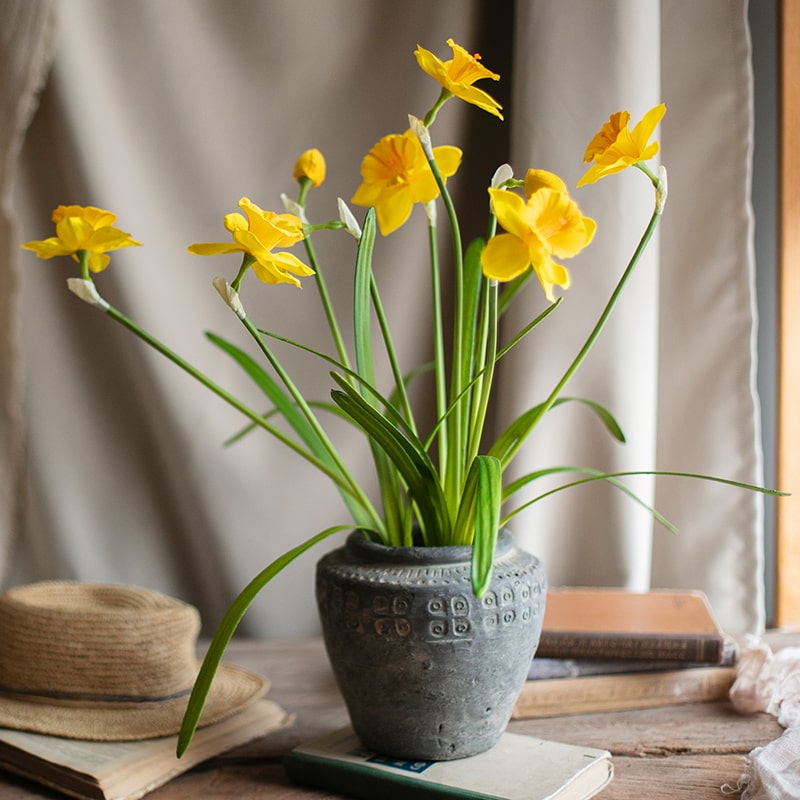 A vibrant 19-inch tall artificial silk yellow daffodil flower stem with two blooms and one bud, featuring realistic green leaves.